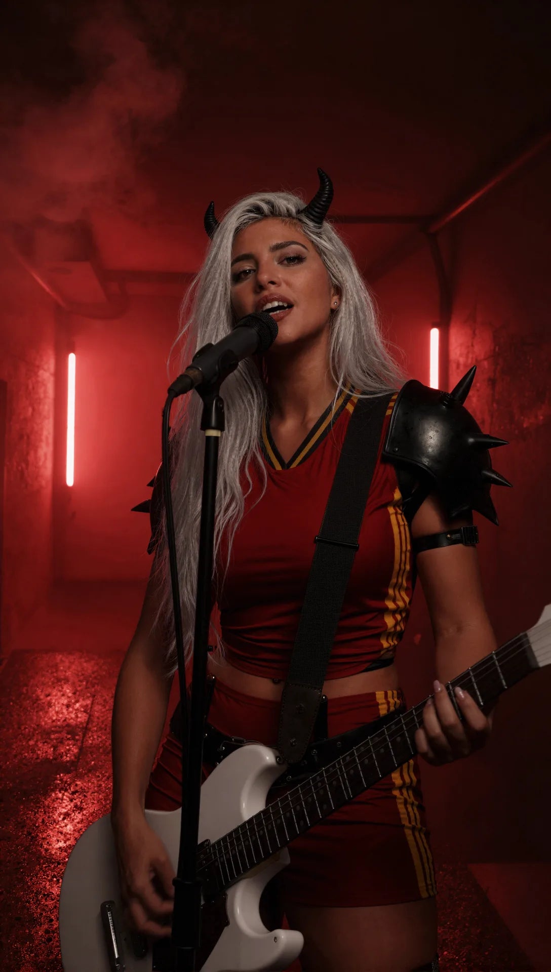 CAVRA cantando con guitarra en una escena roja